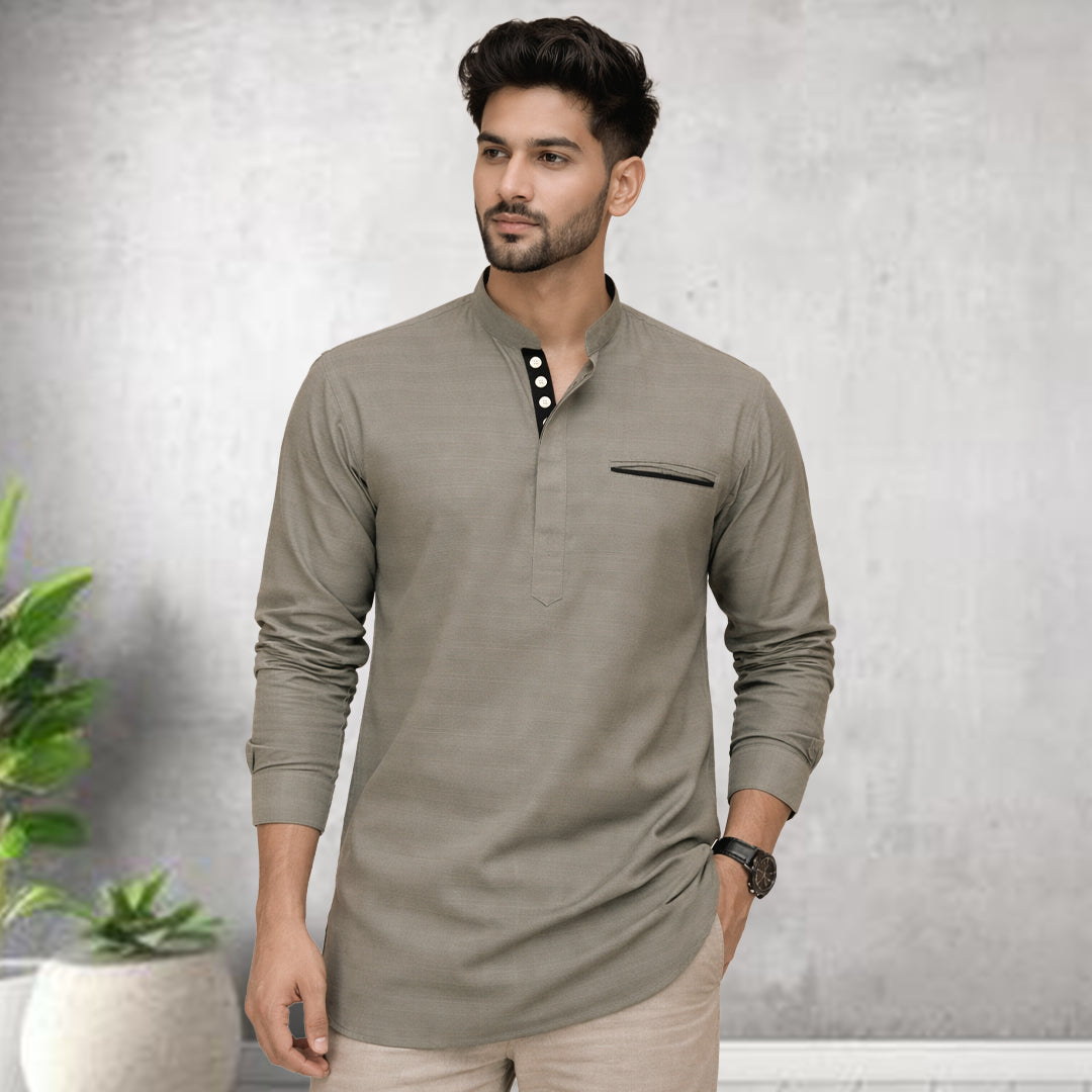 Man wearing a beige long-sleeve shirt with a pocket on a gray background