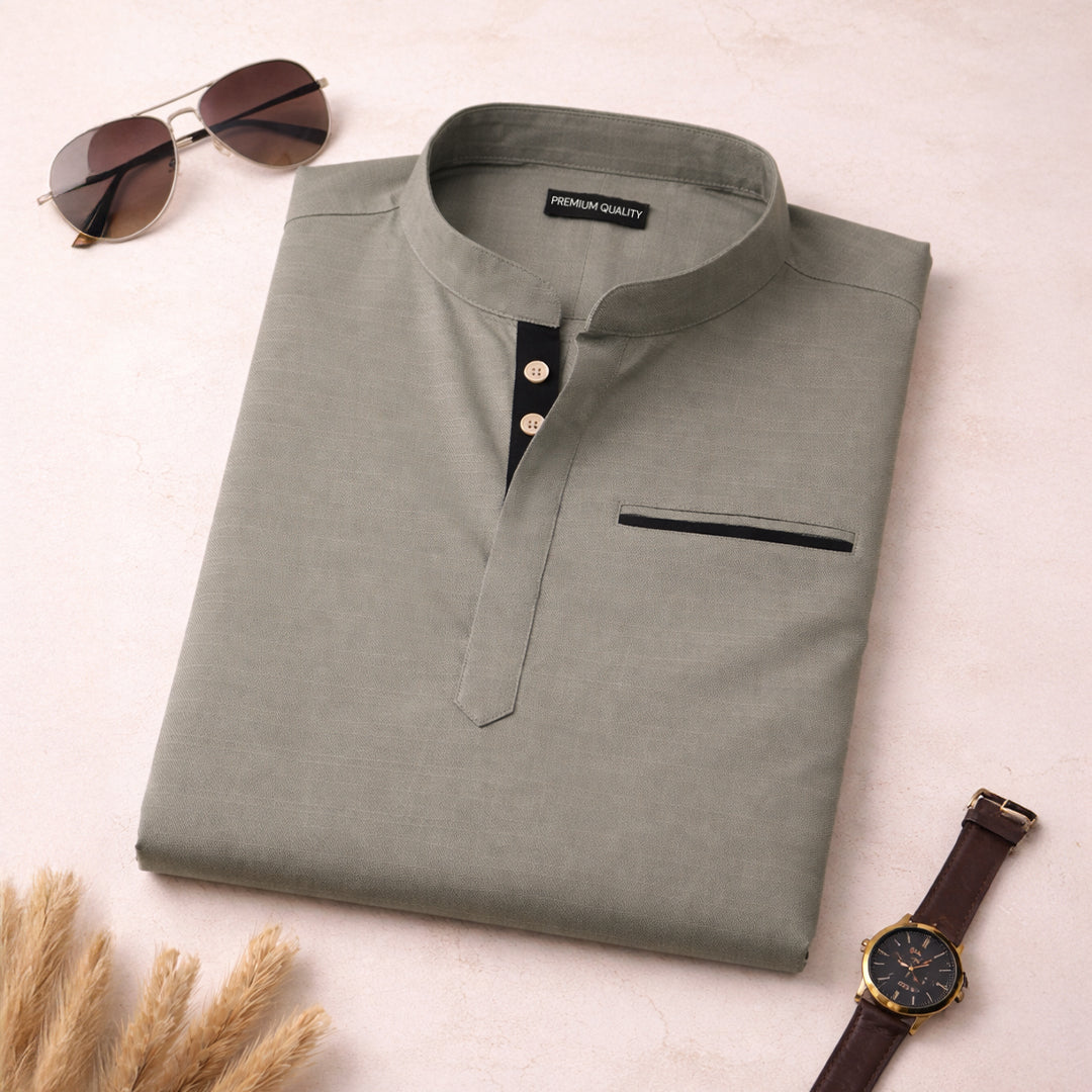 Man wearing a beige long-sleeve shirt with a pocket on a gray background